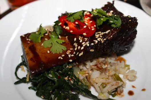 Sichuan style beef ribs in fire sauce with braised greens and garlic rice